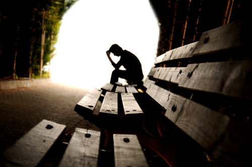 depressed man sitting on bench